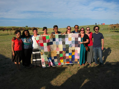 CWB students hold up a quilt